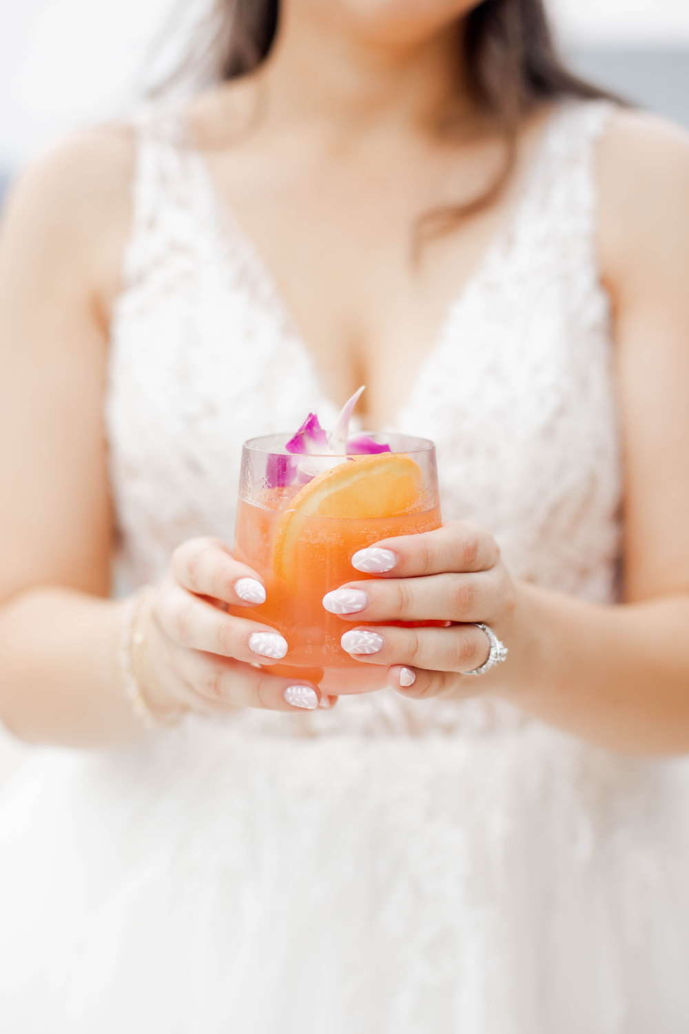 bride holds orange signature cocktail
