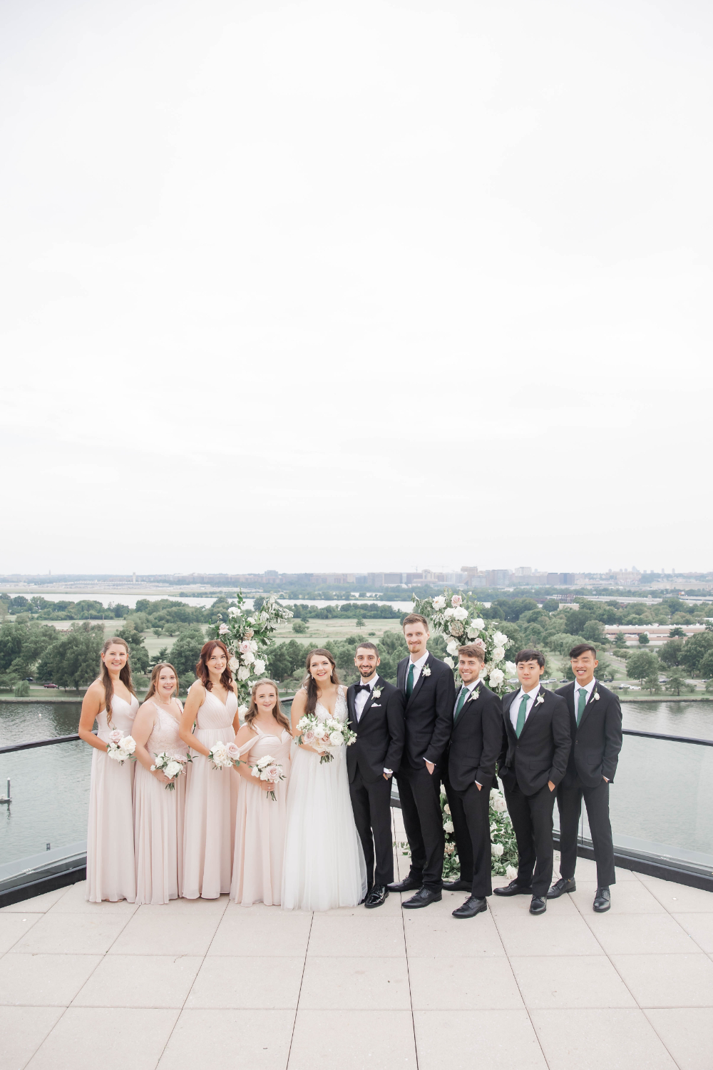 bride and groom pose with wedding party after rooftop ceremony at La Vie