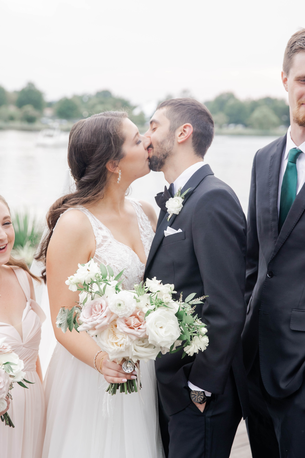 bride and groom sneak a kiss during wedding portraits