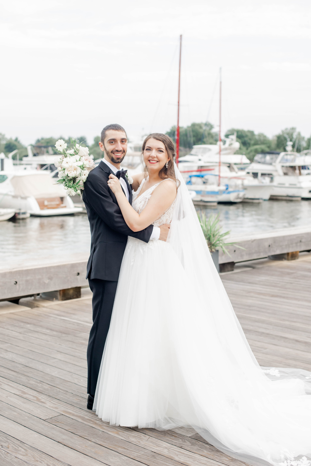 bride and groom pose by DC pier