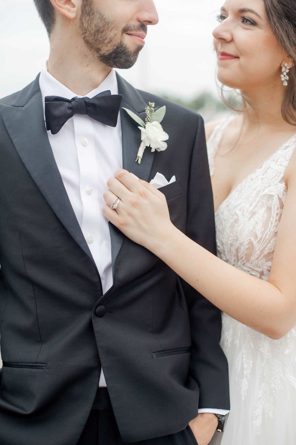 closeup of bride with hand on grooms chest showing off wedding ring