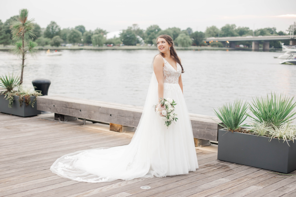 bride poses with white and blush bouquet