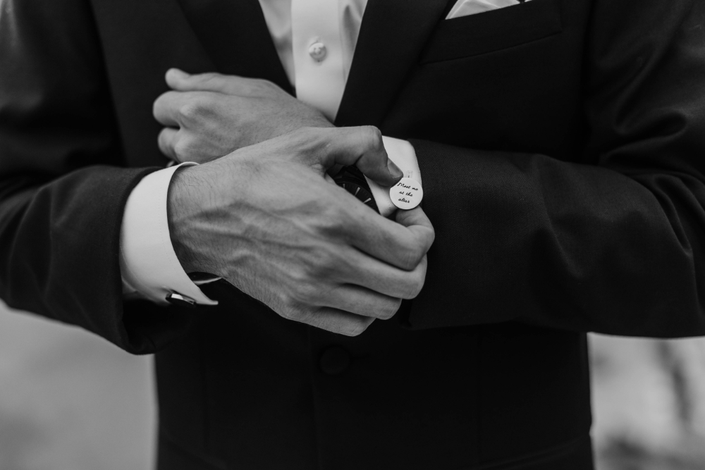 groom touches cufflinks