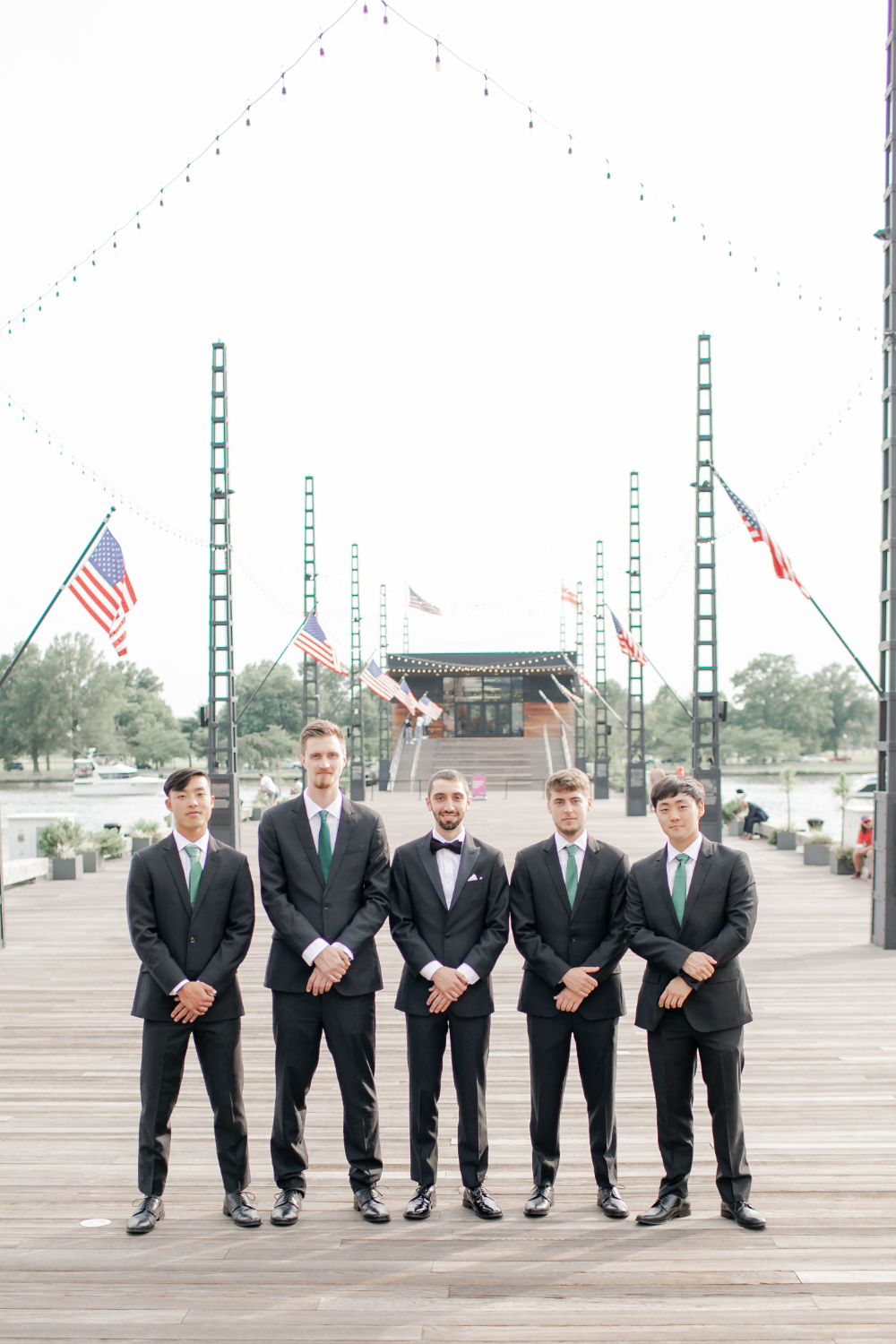 groom and groomsmen pose on DC pier 