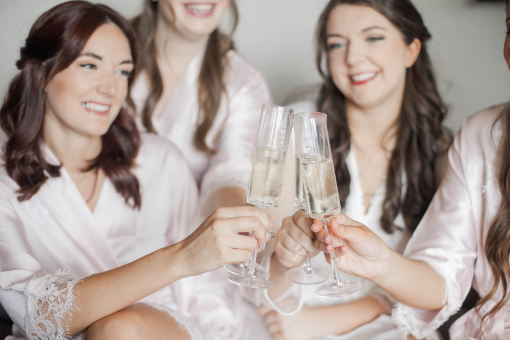 bride and bridesmaids toast champagne