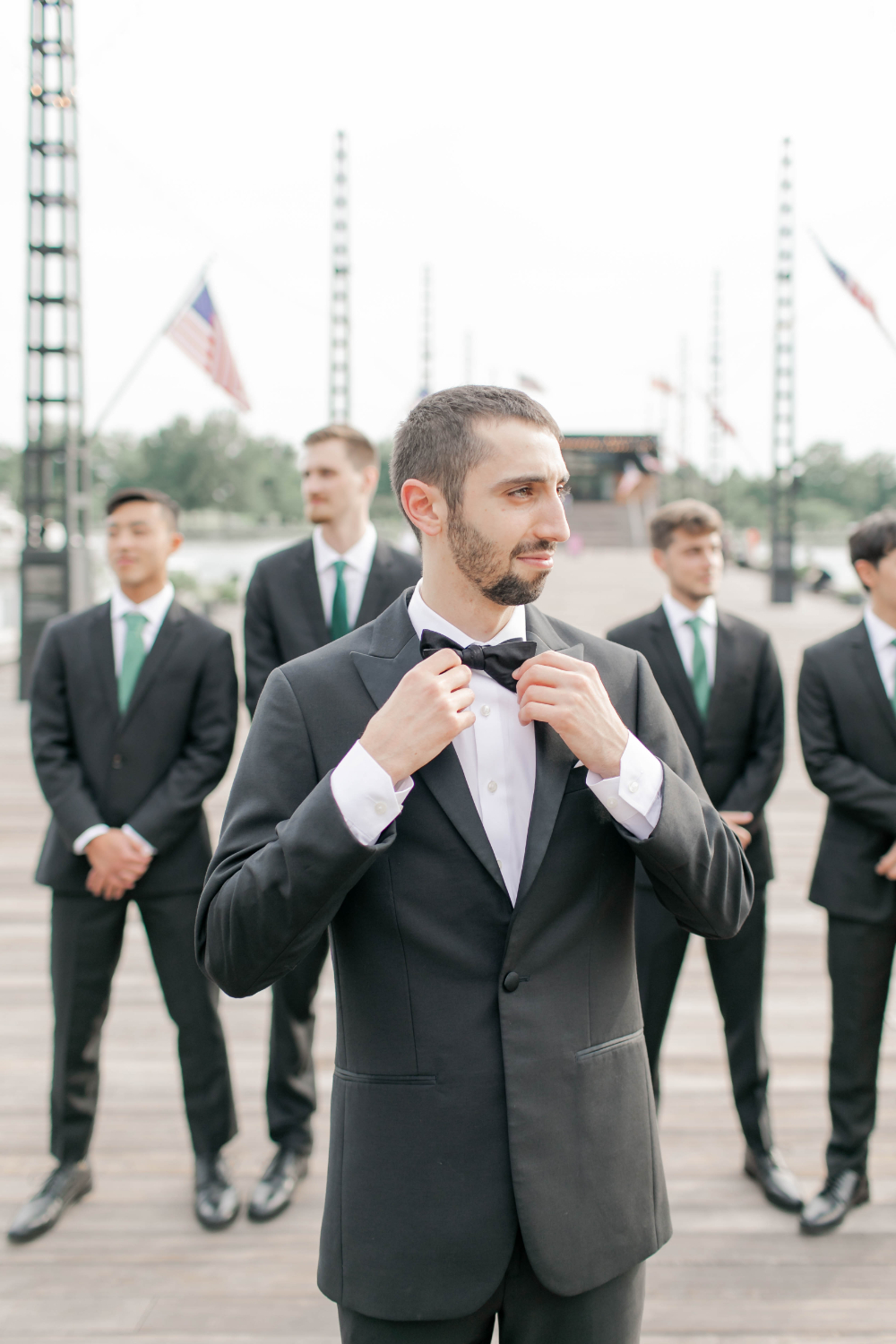 groom and groomsmen pose on DC pier 
