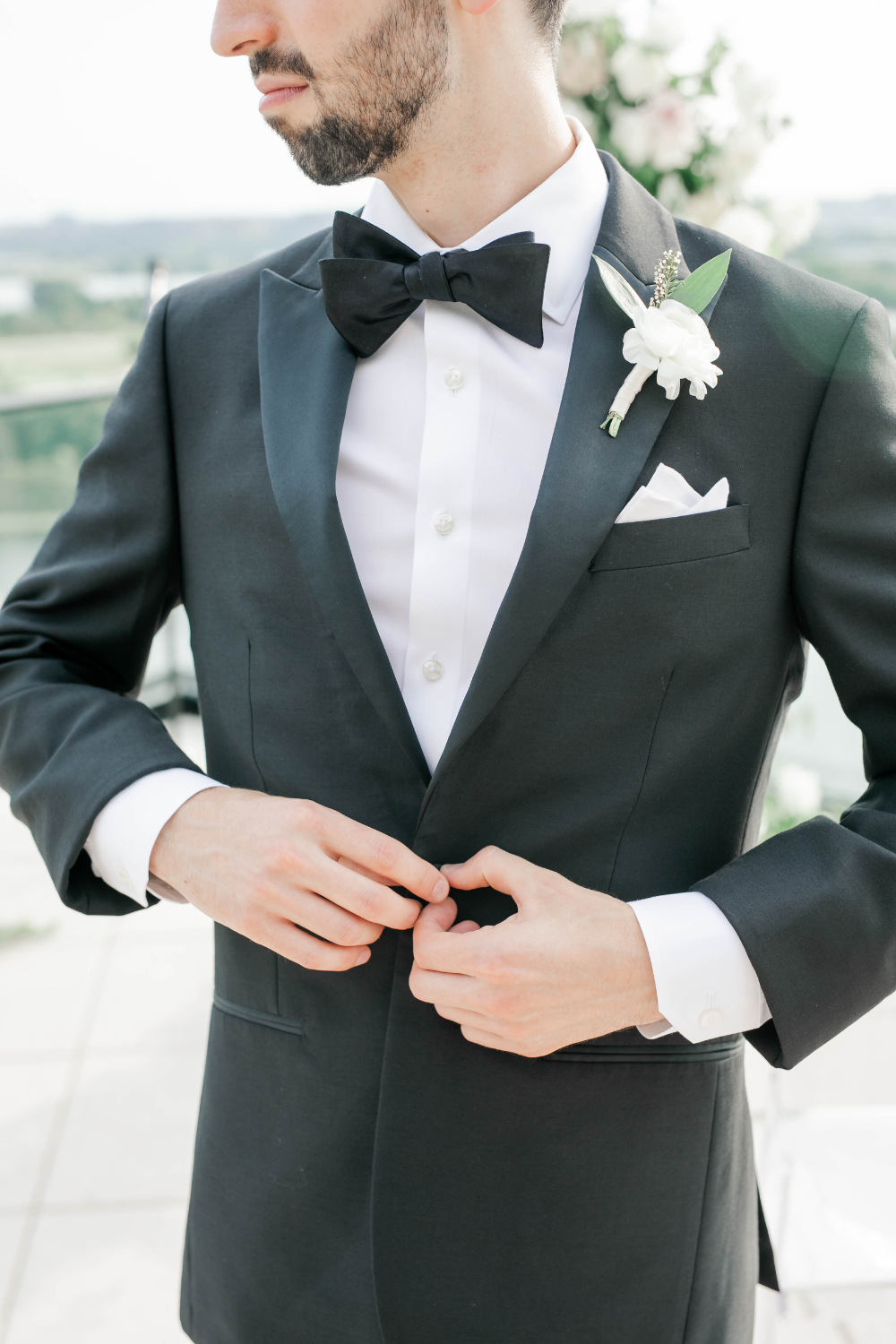 groom puts on his tuxedo