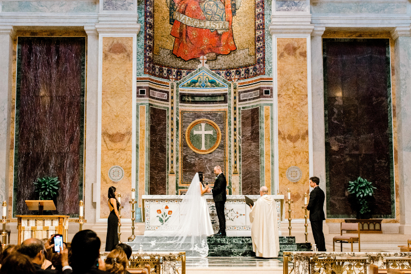 bride and groom stand at altar of St. Matthews Cathedral