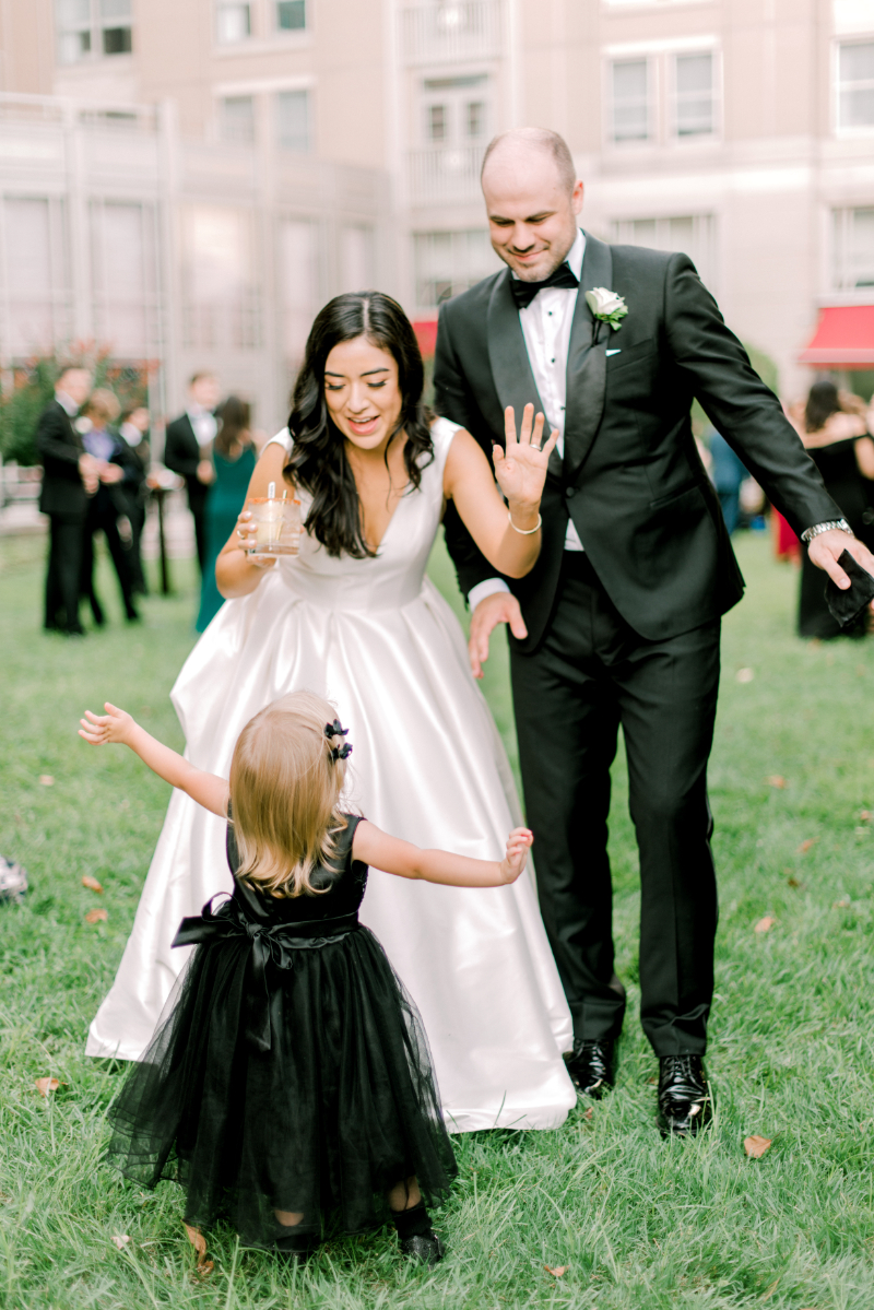 bride and groom dance with flower girl