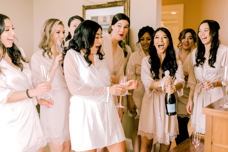 bride pops champagne during getting ready photos