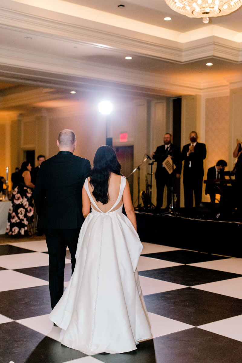 bride and groom dance on dance floor in front of wedding band