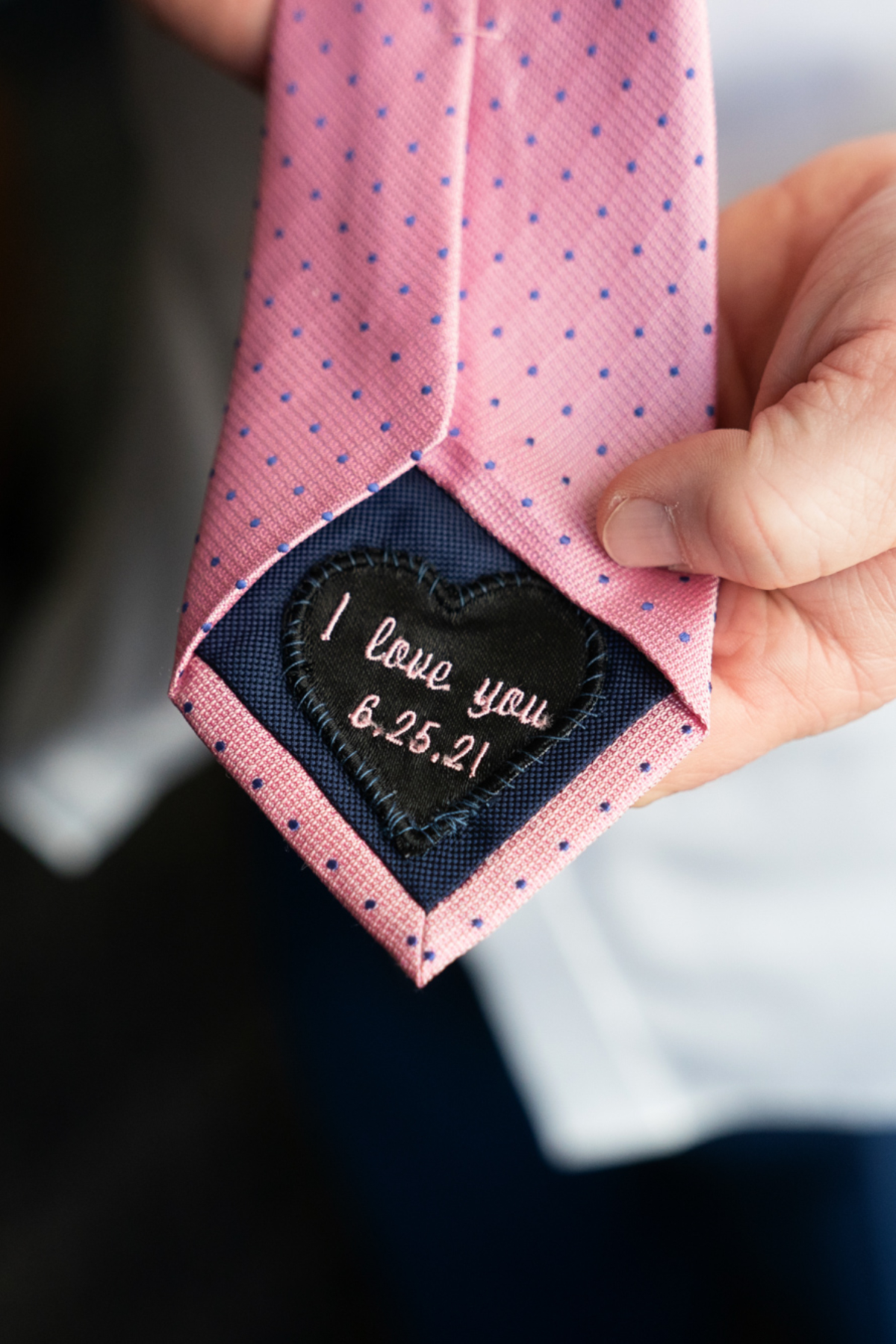 closeup of grooms tie embroidered with wedding date