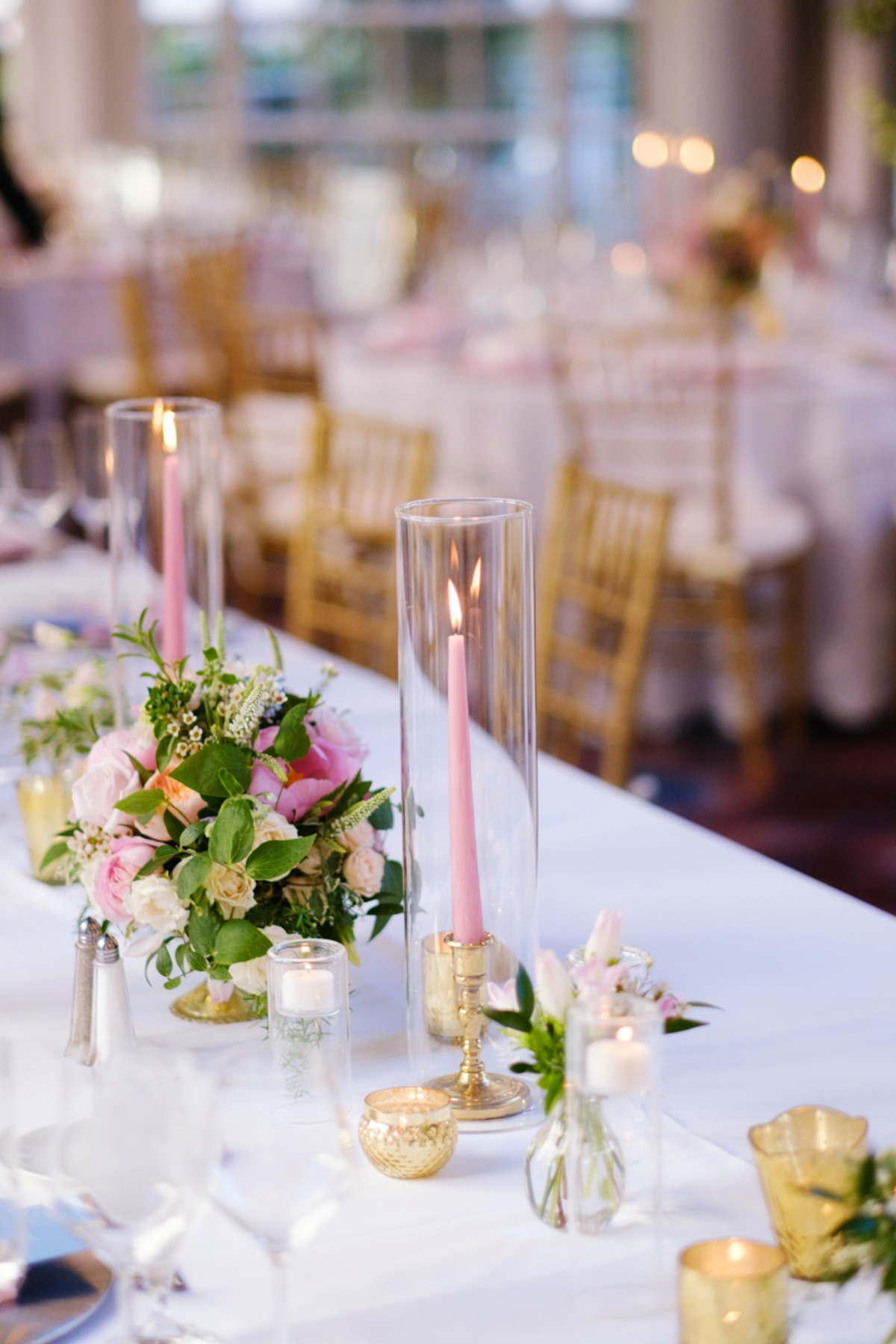 wedding table decor with pink florals and tall pillar candles