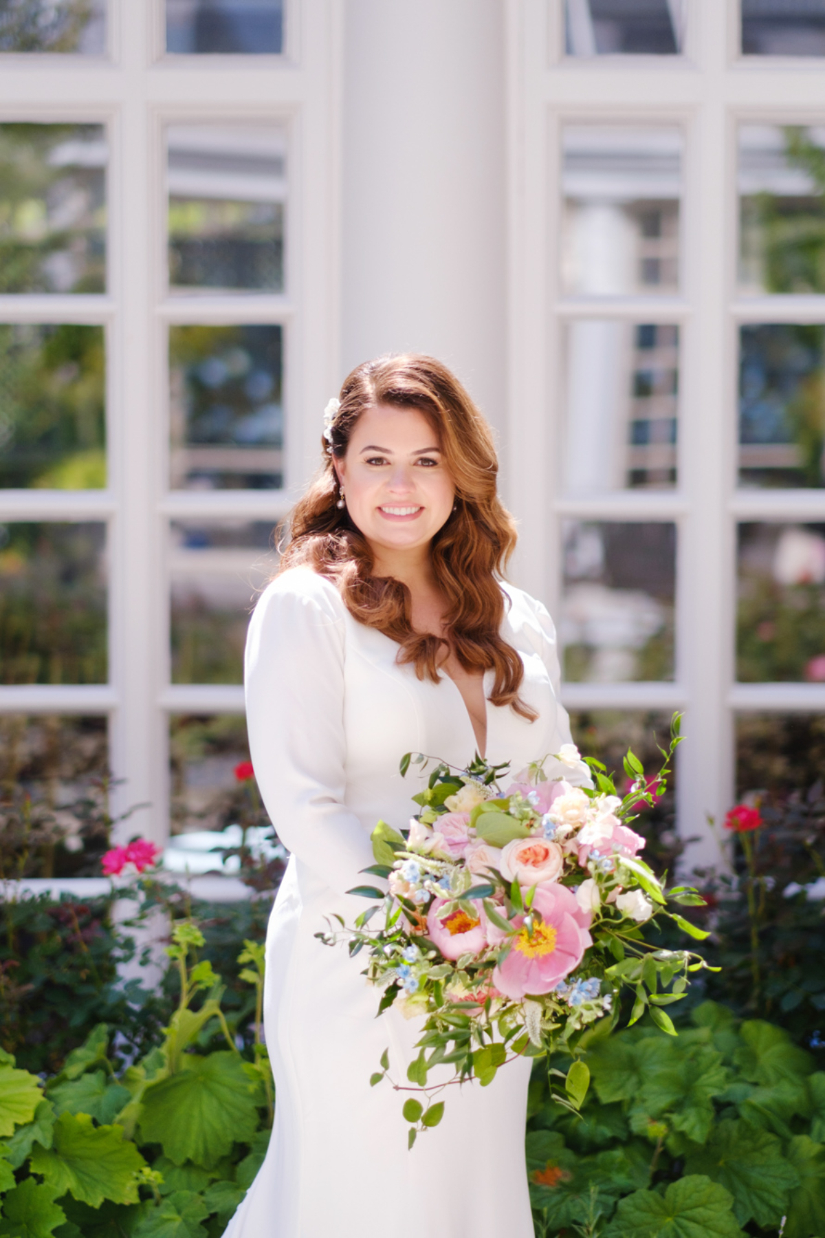 bride stands with bouquet in garden of the Fairmont Washington 