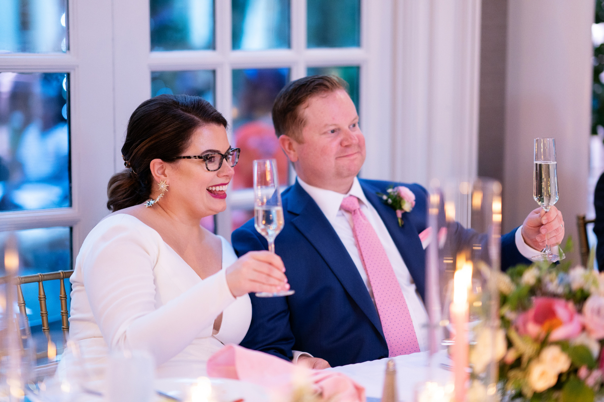 bride and groom listen to toasts at sweetheart table