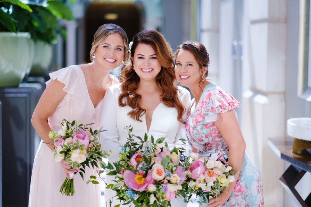 bride stands with her sister and mother