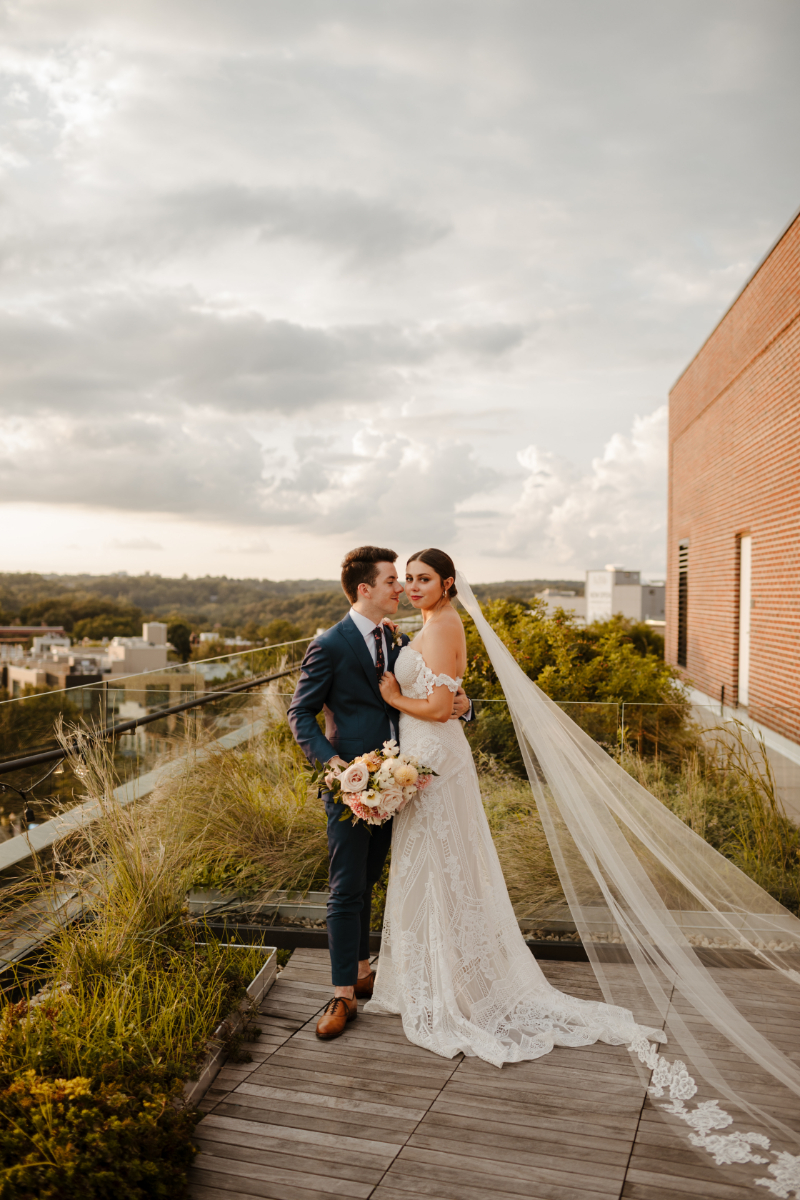 bride and groom pose on rooftop wedding venue