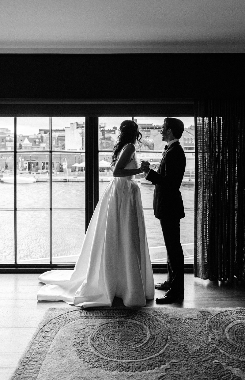 black and white wedding photo of bride and groom holding hands