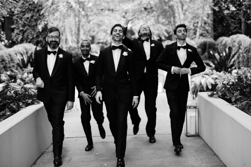 groom walks and laughs with groomsmen