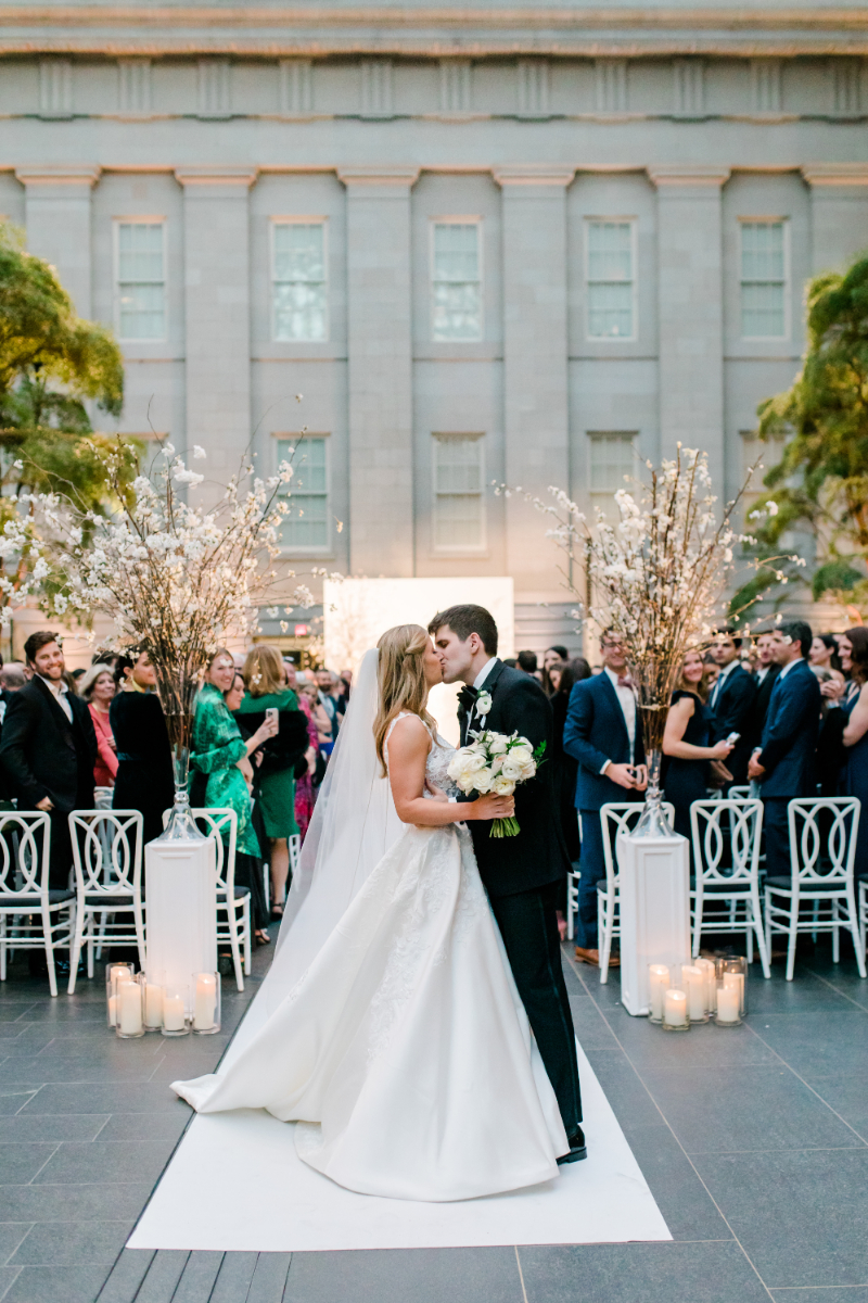 BRIDE AND GROOM KISSING AT WEDDING CEREMONY AT NATIONAL PORTRAIT GALLERY