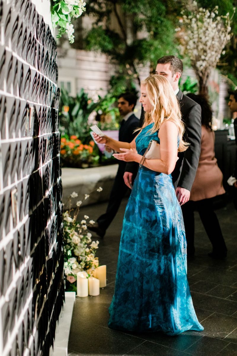 GUESTS ADMIRING PERSONALIZED ESCORT CARD WALL AT WEDDING RECEPTION AT NATIONAL PORTRAIT GALLERY