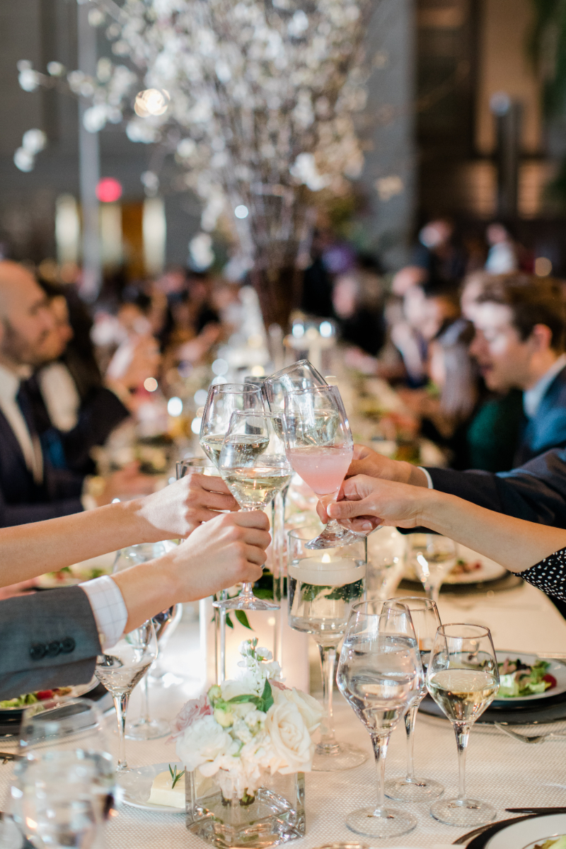 CLOSE UP OF GUESTS TOASTING EACH OTHER AT WEDDING RECEPTION AT NATIONAL PORTRAIT GALLERY
