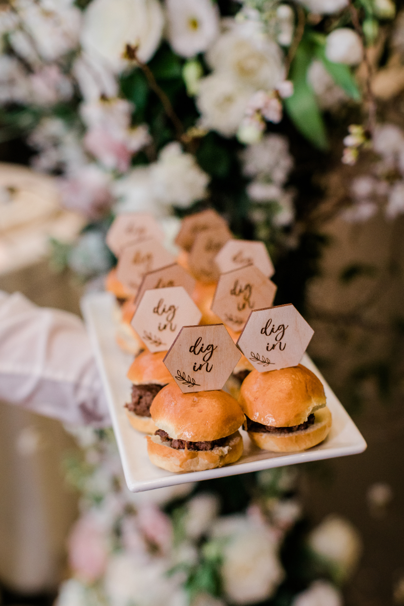 CLOSE UP OF HAMBURGET SLIDERS WITH WOODEN SIGNS THAT SAY "DIG IN" AT WEDDING RECEPTION AT NATIONAL PORTRAIT GALLERY KOGOD COURTYARD