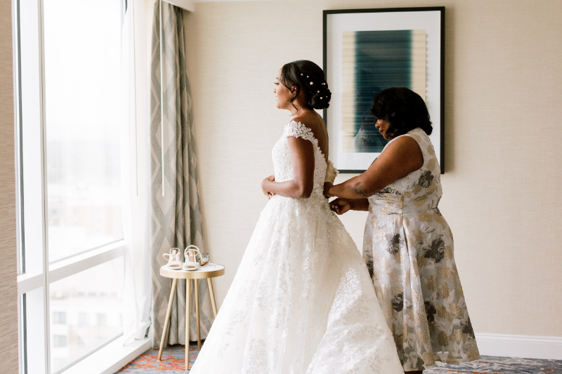 BRIDES MOTHER HELPING HER GET GET READY 