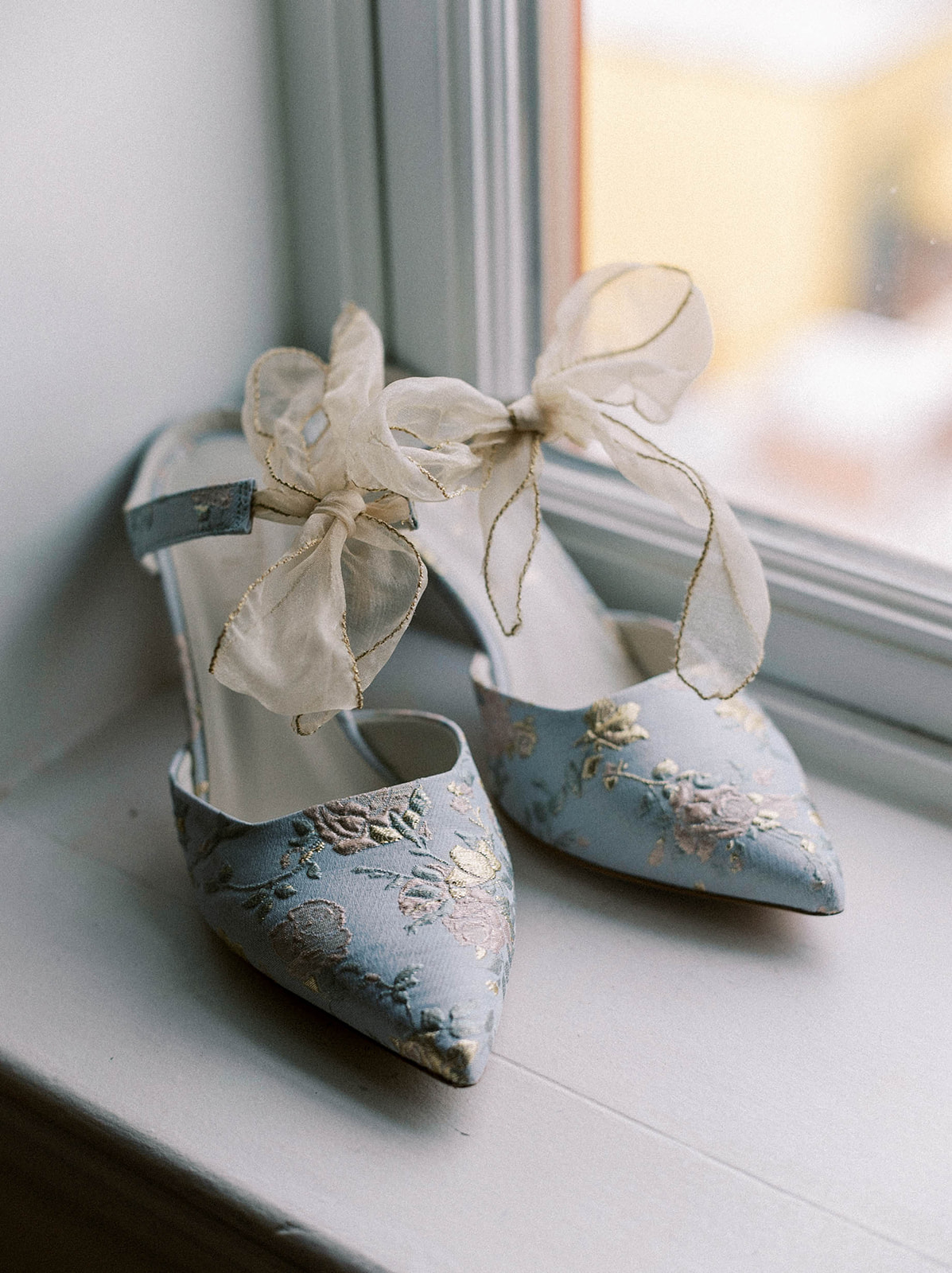 BLUE WEDDING SHOES SITTING AT A WINDOW